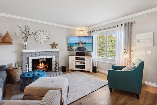 living room featuring baseboards, ornamental molding, wood finished floors, and a fireplace