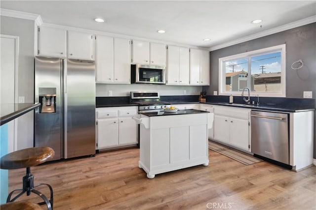 kitchen with crown molding, stainless steel appliances, white cabinets, and a sink