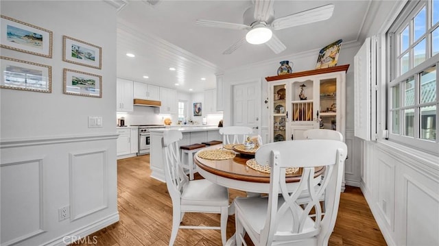 2617 Huntington Ln Unit B, Redondo Beach, CA 90278 - dining space with light wood-type flooring, a decorative wall, crown molding, a ceiling fan, and wainscoting