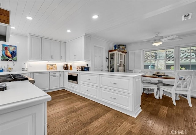 2617 Huntington Ln Unit B, Redondo Beach, CA 90278 - kitchen featuring light wood-style flooring, a peninsula, recessed lighting, light countertops, and white cabinetry