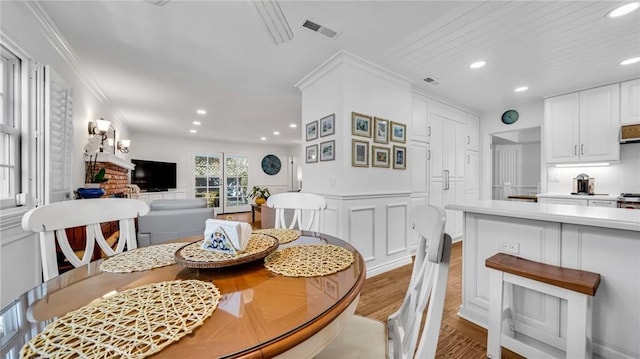 2617 Huntington Ln Unit B, Redondo Beach, CA 90278 - dining area featuring light wood-style floors, recessed lighting, crown molding, a decorative wall, and wainscoting