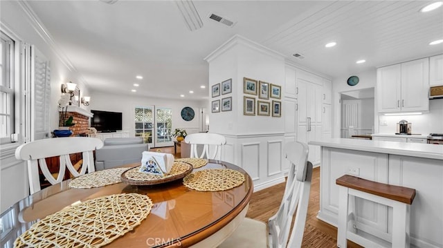 2617 Huntington Ln Unit B, Redondo Beach, CA 90278 - dining room featuring light wood-style flooring, recessed lighting, crown molding, a decorative wall, and a wainscoted wall