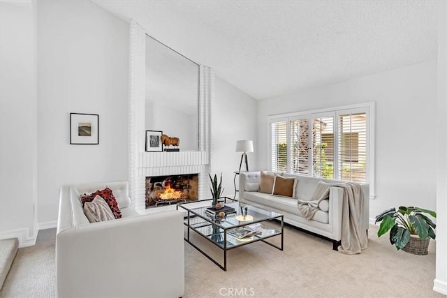 living area featuring a fireplace, a textured ceiling, carpet, baseboards, and lofted ceiling