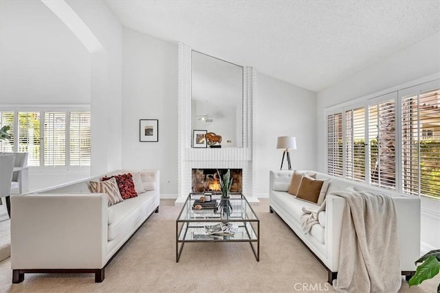 living area featuring arched walkways, high vaulted ceiling, light colored carpet, and a fireplace