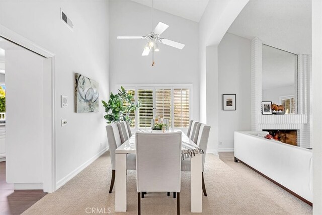 dining room with a healthy amount of sunlight, high vaulted ceiling, ceiling fan, and baseboards