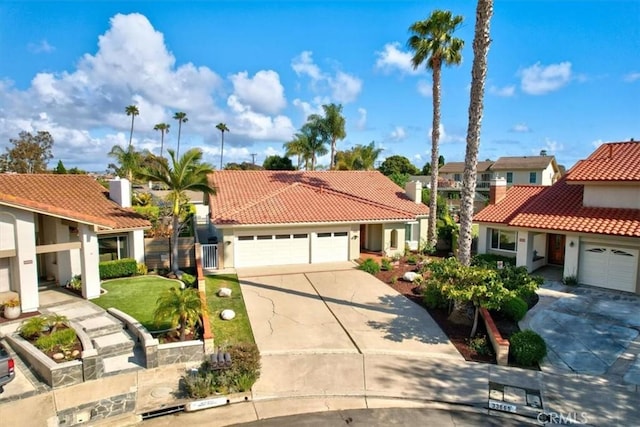 mediterranean / spanish house with stucco siding, a tile roof, and concrete driveway