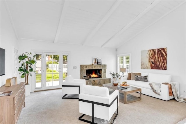 living area featuring a tiled fireplace, lofted ceiling with beams, and light carpet