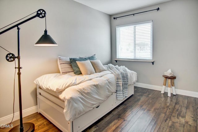 bedroom with baseboards and dark wood-style flooring