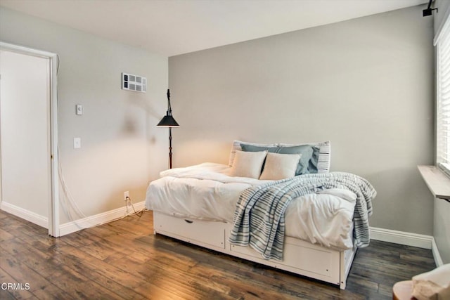 bedroom with baseboards and wood finished floors
