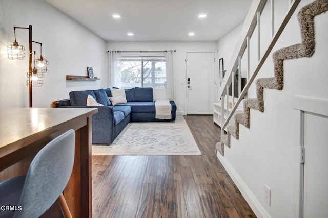 living area featuring recessed lighting, dark wood-style flooring, and stairs