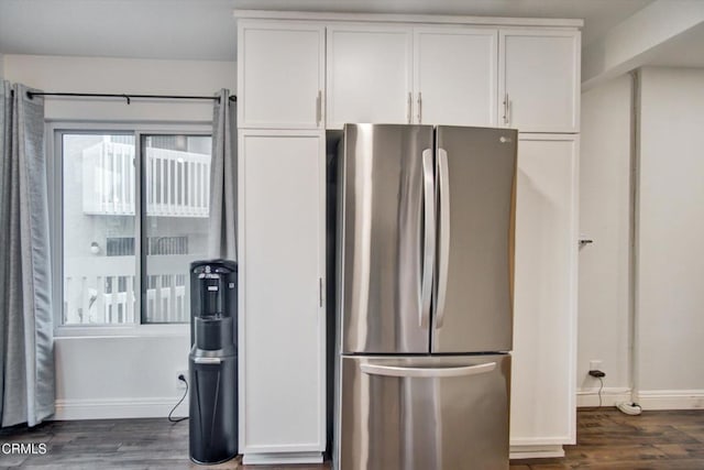 kitchen with freestanding refrigerator, white cabinets, baseboards, and wood finished floors