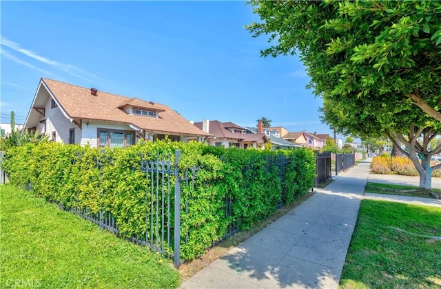 exterior space with fence, a yard, and a residential view