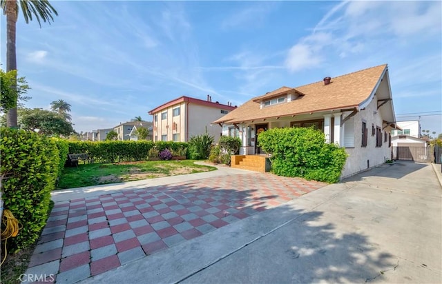 mediterranean / spanish-style house with stucco siding, a gate, concrete driveway, and a shingled roof