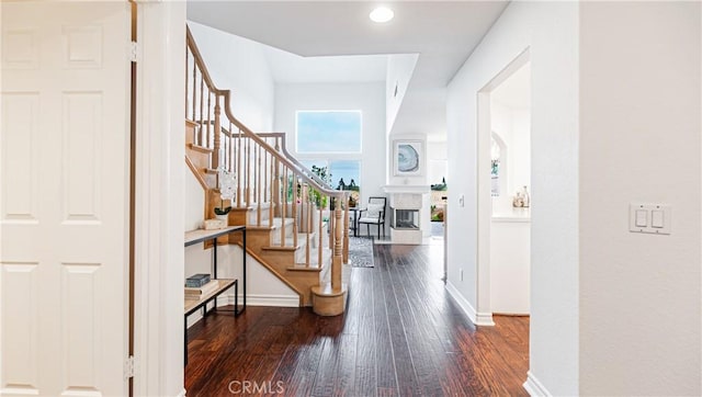 foyer entrance with a fireplace, recessed lighting, baseboards, wood finished floors, and stairway