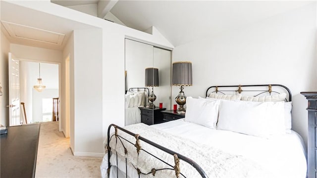 carpeted bedroom with a closet, attic access, baseboards, and lofted ceiling