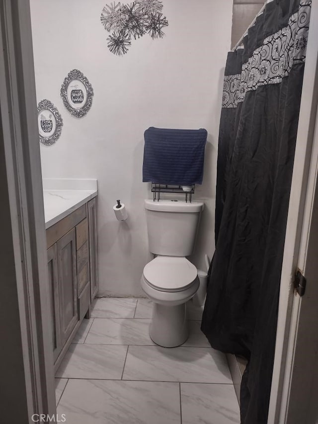 8782 Peach Ave, Hesperia, CA 92345 - bathroom with marble look tile flooring, toilet, vanity, and curtained shower