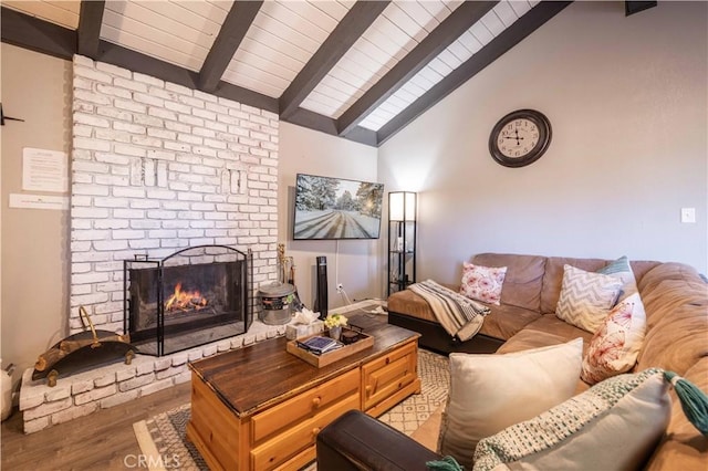 living area featuring a brick fireplace, beam ceiling, wood finished floors, and wood ceiling
