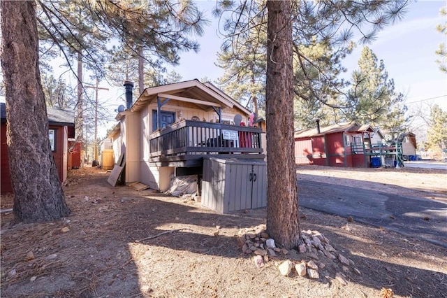back of property featuring a wooden deck and a chimney
