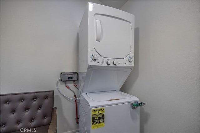washroom featuring stacked washer / dryer and laundry area