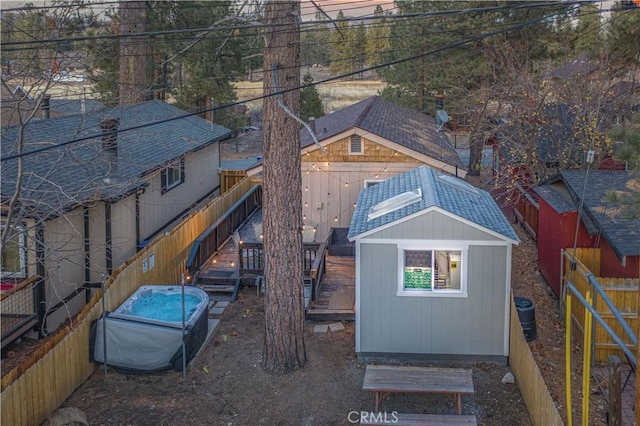 exterior space featuring an outbuilding, a deck, and a fenced backyard