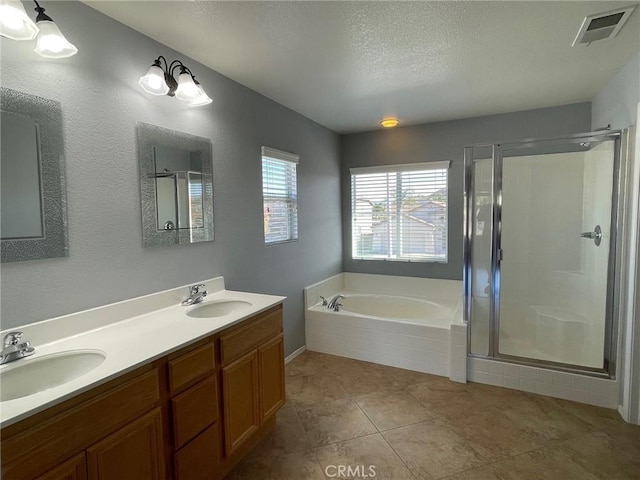 31556 Umbria Ln, Winchester, CA 92596 - bathroom featuring a bath, a shower stall, double vanity, a textured ceiling, and tile patterned flooring