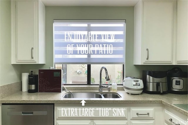 kitchen featuring stainless steel dishwasher, a sink, white cabinets, and a wealth of natural light