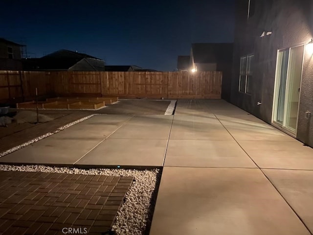 patio at twilight featuring fence