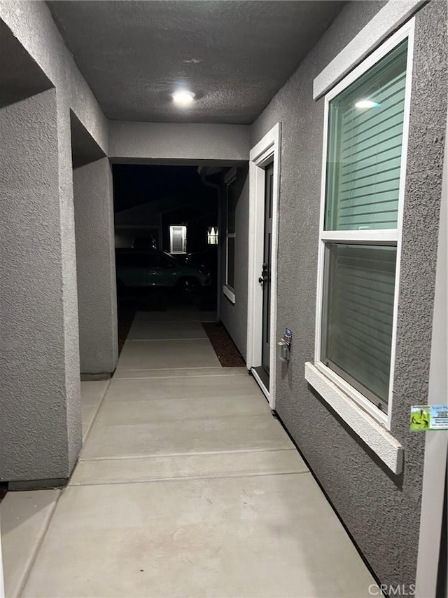 hallway with a textured wall and concrete flooring