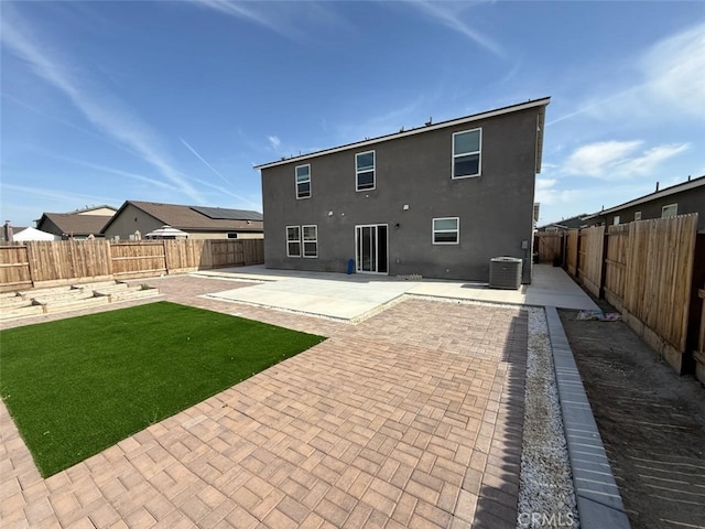 back of house with a yard, central AC unit, a fenced backyard, and a patio area
