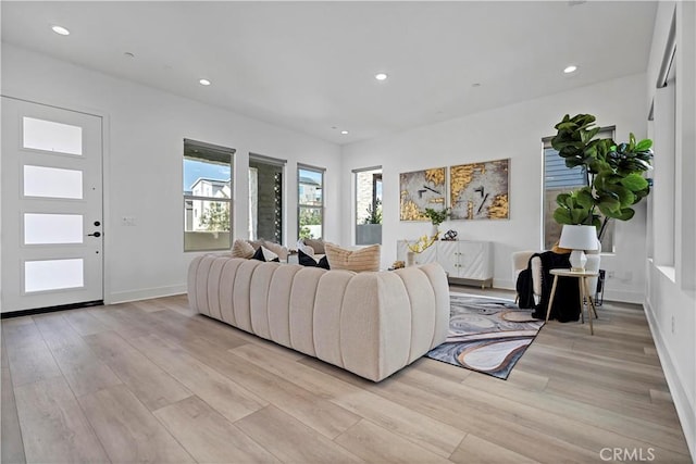 living room with light wood-type flooring, recessed lighting, and baseboards