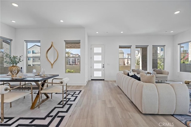 living room featuring recessed lighting, baseboards, and light wood-type flooring