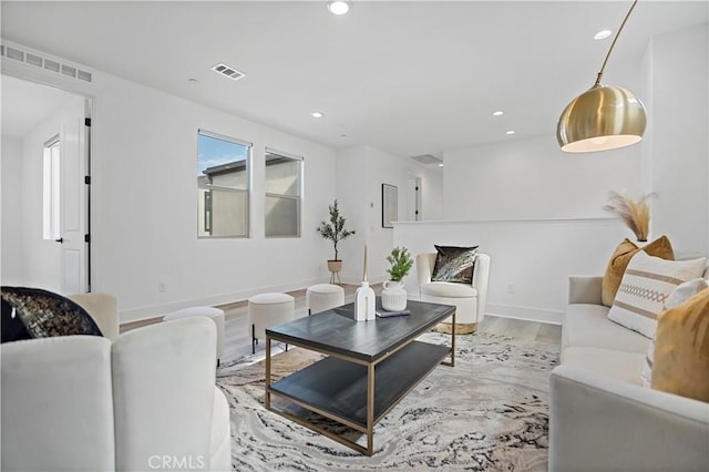 living room with a healthy amount of sunlight, wood finished floors, and visible vents