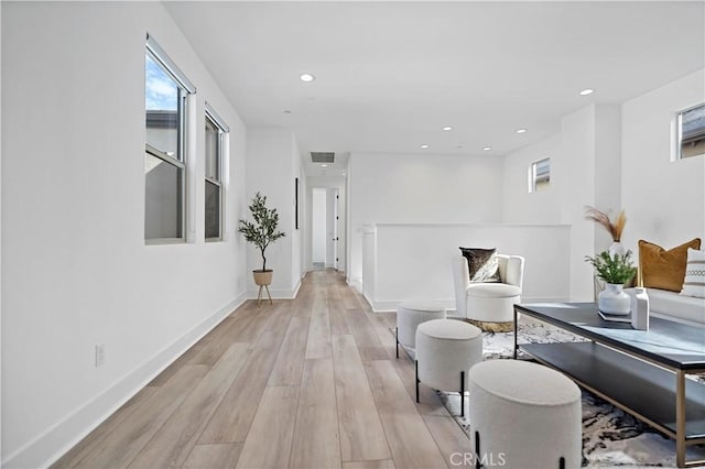 hallway with recessed lighting, baseboards, visible vents, and light wood finished floors