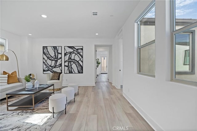 corridor with recessed lighting, baseboards, a wealth of natural light, and light wood finished floors
