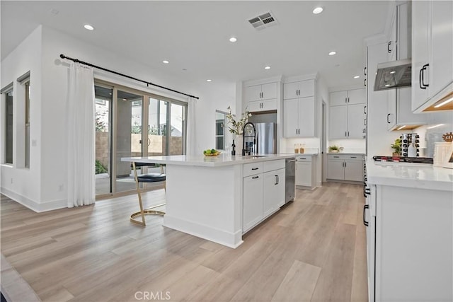 kitchen with stainless steel dishwasher, light wood-style floors, recessed lighting, light countertops, and a sink