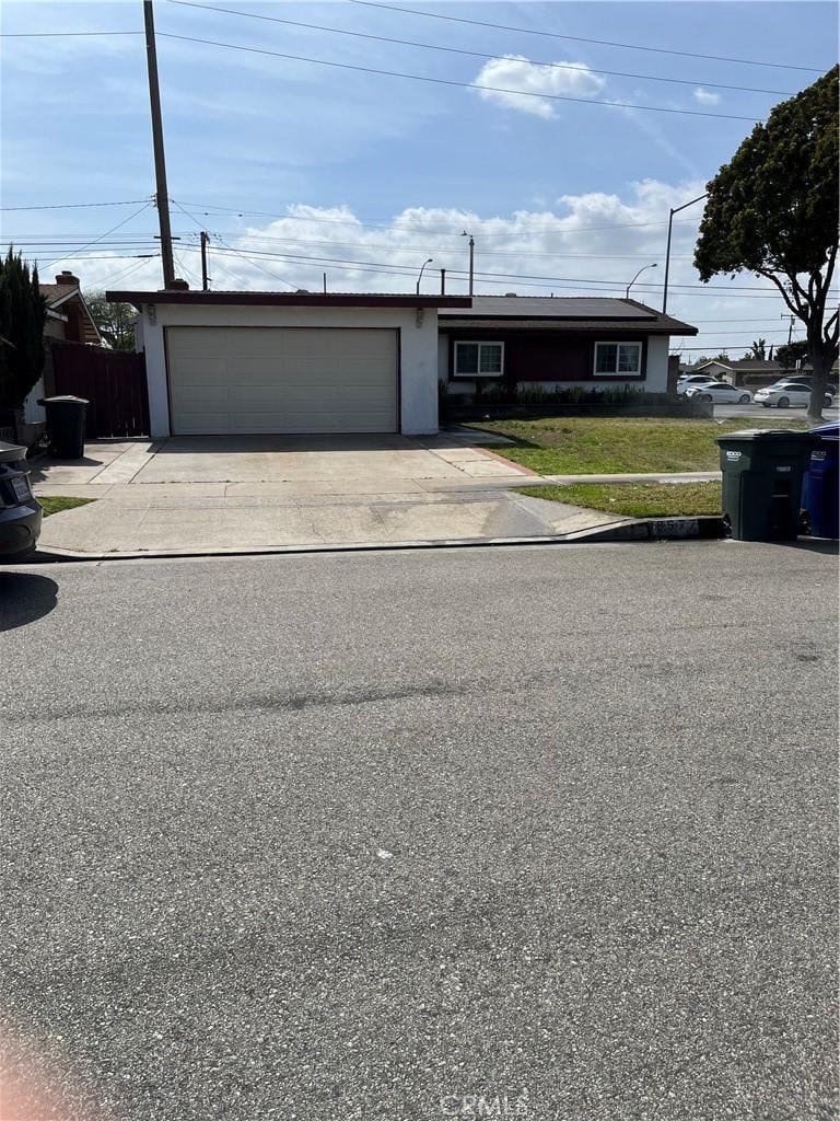 view of front of home featuring fence, an attached garage, driveway, and a front yard
