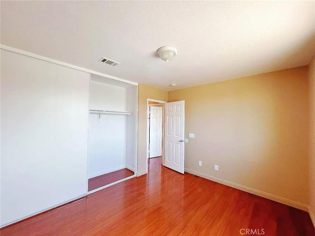 14627 Palm St, Adelanto, CA 92301 - unfurnished bedroom featuring wood finished floors and a closet