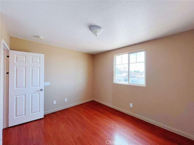 14627 Palm St, Adelanto, CA 92301 - empty room with wood finished floors and a textured ceiling