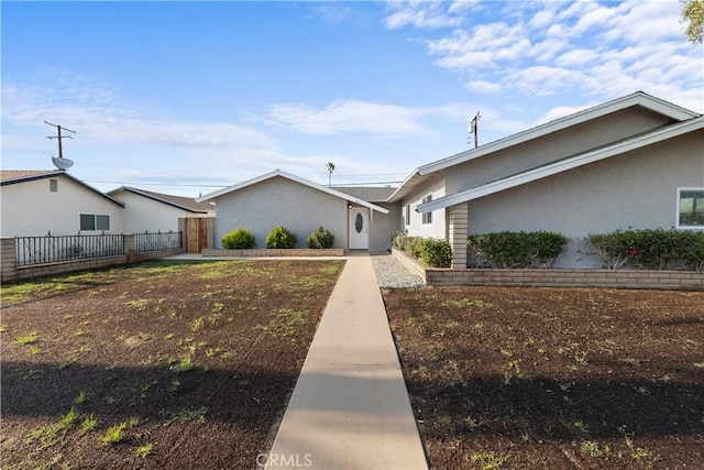 view of front of property featuring stucco siding and fence
