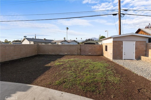 view of yard with a fenced backyard and an outdoor structure