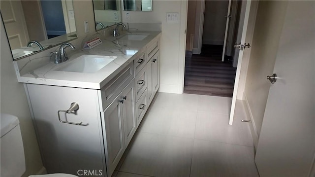 5183 Peony Ct, Riverside, CA 92506 - bathroom featuring double vanity, toilet, baseboards, and a sink