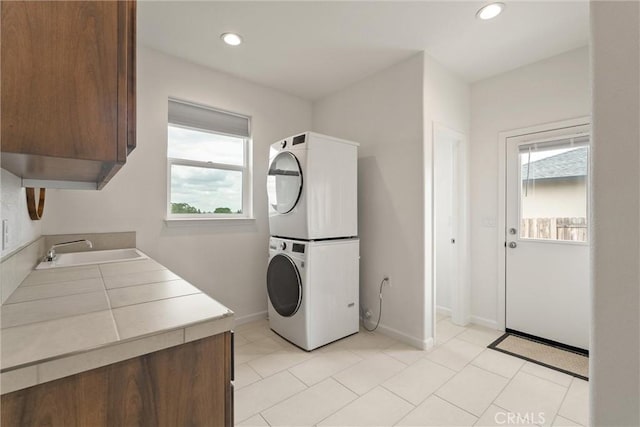 1982 Dawncrest Dr, Chico, CA 95928 - clothes washing area featuring stacked washer and dryer, a sink, cabinet space, and a healthy amount of sunlight