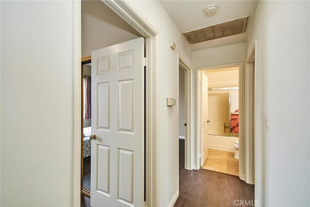 hallway featuring visible vents and dark wood-type flooring
