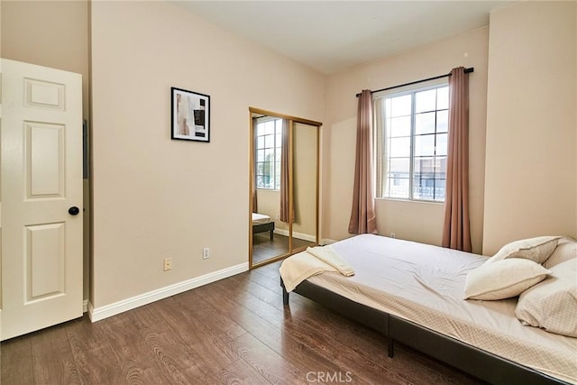 bedroom featuring baseboards, multiple windows, and dark wood-style floors