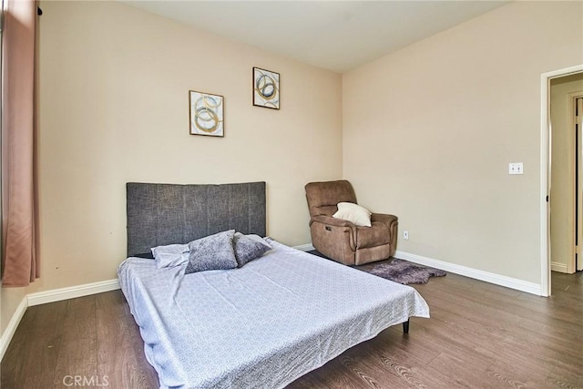bedroom with baseboards and wood finished floors