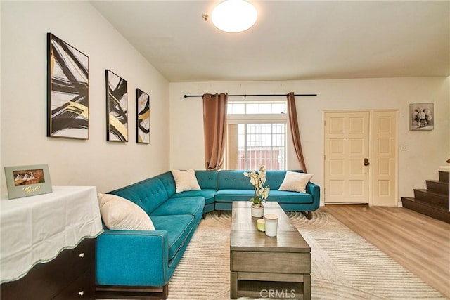 living room with wood finished floors and stairway