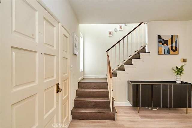 stairs with baseboards and wood finished floors