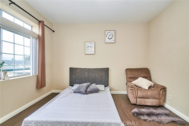 bedroom with baseboards and dark wood finished floors