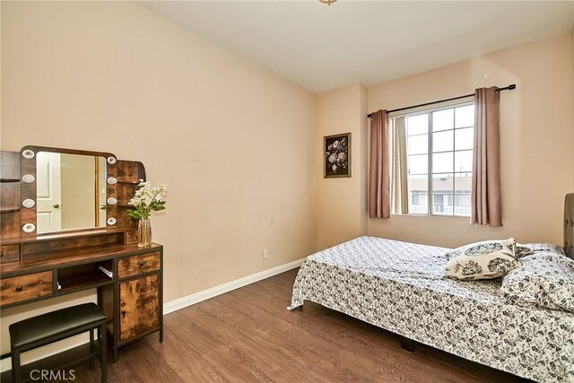 bedroom featuring baseboards and wood finished floors