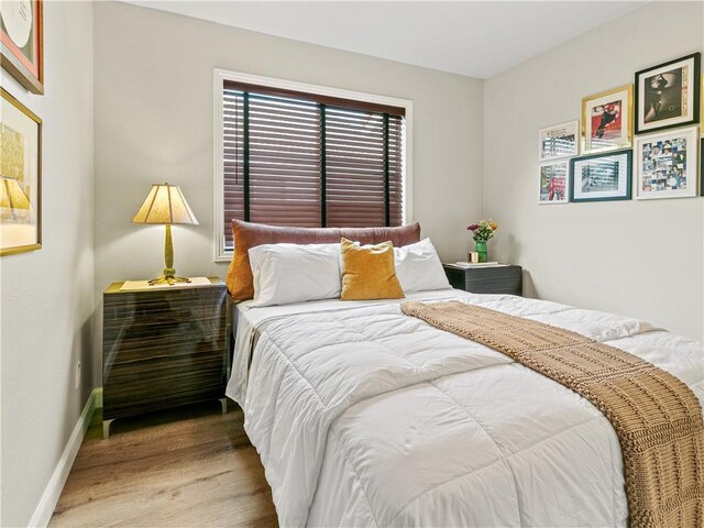 bedroom with baseboards and wood finished floors
